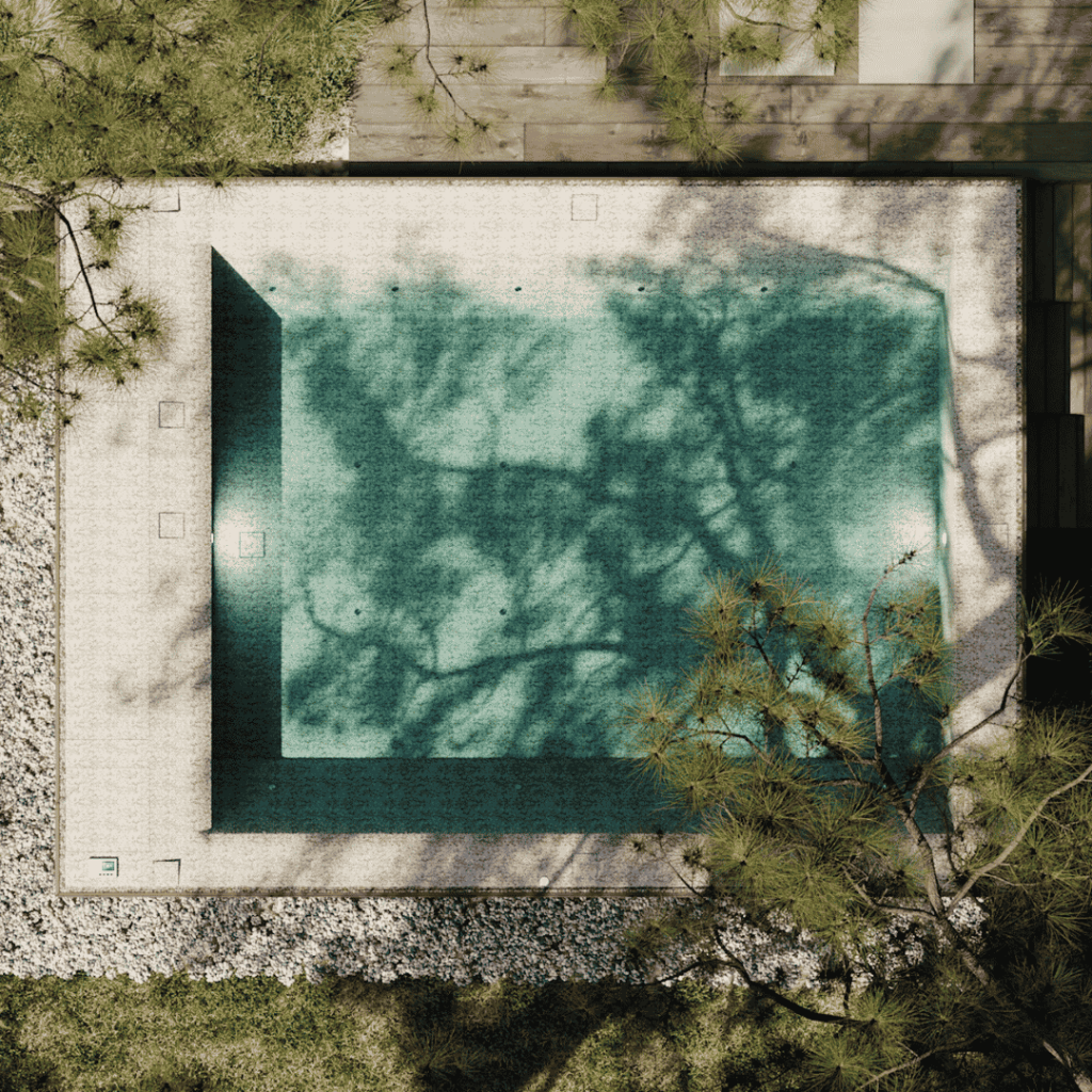 Vue aérienne d'une mini-piscine design intégrée dans un jardin paysager avec terrasse et végétation naturelle