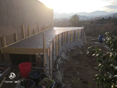 Mur de soutènement habillé en pierres sèches intégré à un lagon Bio.design et une terrasse en pierre naturelle en Ardèche