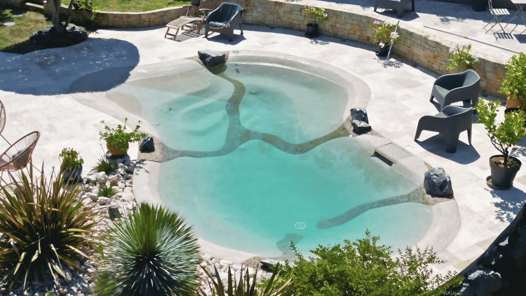Transformation d'une piscine hors-sol en lagon Bio.design avec mur de soutènement en pierres sèches et terrasse en pierre naturelle en Ardèche