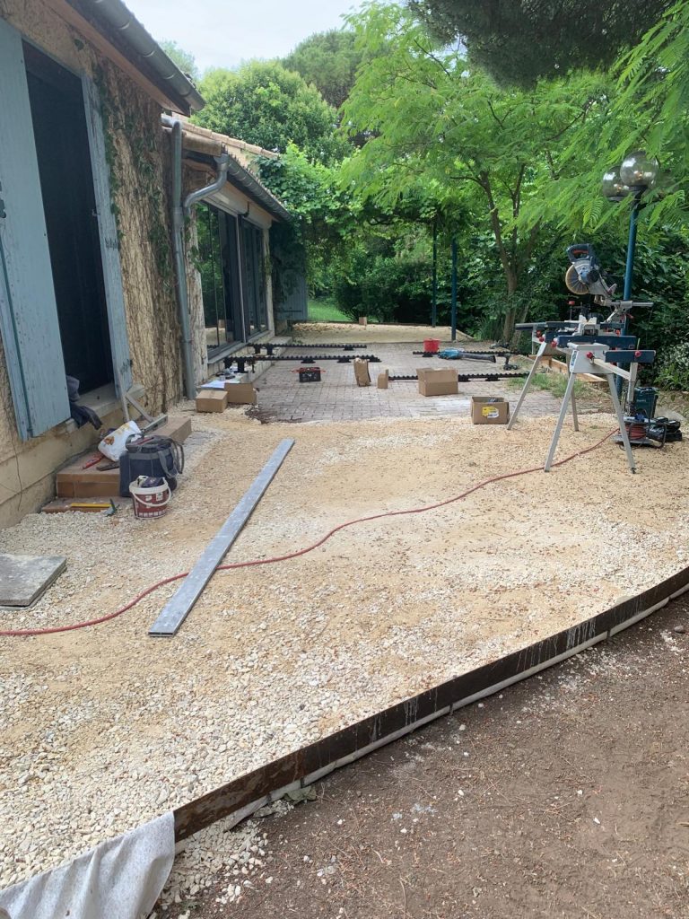 Préparation du terrain avant la pose d'une terrasse en bois Thermopin® avec création des niveaux et protection du sol en Ardèche.