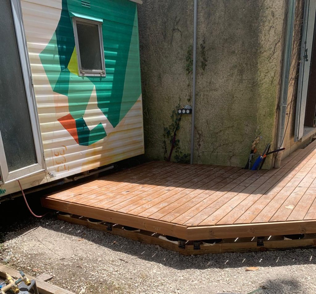 Terrasse en bois Thermopin® réalisée autour d'un bungalow avec fixation invisible Grad®.
