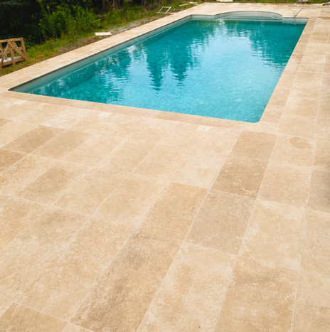 Terrasse en pierre claire et plage de piscine aménagées en Ardèche